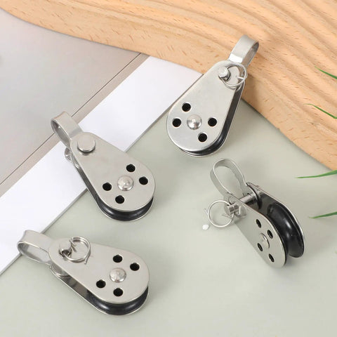 4 Pack Nylon Marine Pulleys With 316 Stainless Steel Bearings shown on table, compact design for sailboats, fits 0.08 to 0.32 inch ropes.