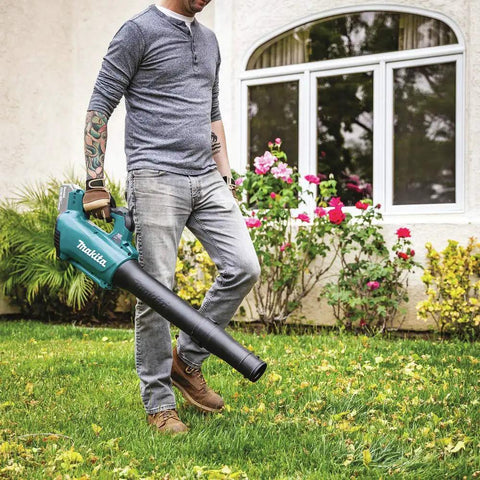 Man using 18V LXT Brushless Cordless Blower With Cruise Control, Variable Speed Trigger, and Speed Lock in garden
