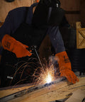 Person welding in workshop wearing Heavy Duty Leather Welding Apron With Six Pockets For Pro Welders, heat resistant, flame retardant, black