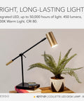 Lit 7W LED Desk Lamp With Qi Wireless Charging Pad And USB Port, adjustable arm, black and brass, on wooden desk