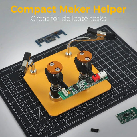Dual Clamp Soldering Helper Stand With Quick Release Third Hand For Electronics PCB Repair DIY Projects Jewelry Craft No Fuss Soldering Aid Station Adjustable Compact Yellow Black with circuit board on grid mat.
