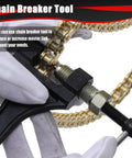 Chain breaker tool pressed against a gold 420 drive chain, close-up view.