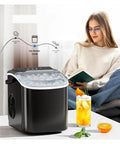 Hella Fast Portable Countertop Ice Maker Drops Fresh Cubes In Six Minutes With Sturdy Carry Handle Self Cleaning Tech pushes out ice with glass of refreshing drink.