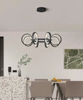 Dope Modern LED Chandelier With Six Black Ring Pendant Lights in dining room, minimalist round fixture over table.