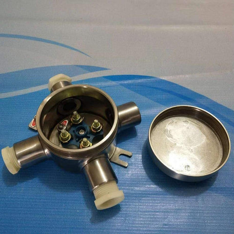 Front view of stainless steel explosion-proof junction box, lid off, blue terminal plate and brass studs.