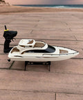 Remote Control Boat 4CH Electric RC Watercraft Yacht Style Sail Cruiser, perfect for lake and pool, shown on wooden deck.