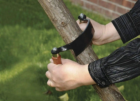 Pro Grade 10 Inch Curved Draw Knife Heavy Duty Woodworking Shaving Tool cutting bark from a log outdoors.