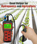 Person using All In One Water Quality Meter For Aquariums And Hydroponics With Dissolved Oxygen pH Salinity TDS EC And Temp Bluetooth Data Logging And Calibration Kit For Fish Tanks Ponds Brewing in a hydroponic setup.