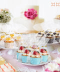 Cupcakes in Clear Cellophane Treat Bags 5x7 Inches, 100 Pack With Gold 3 Inch Twist Ties for Party Favors on a decorated table.