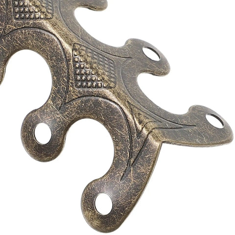 Close-up of Heavy Duty Antique Metal Corner Guards 20 Pack For Cabinets And Albums with decorative design and predrilled holes.