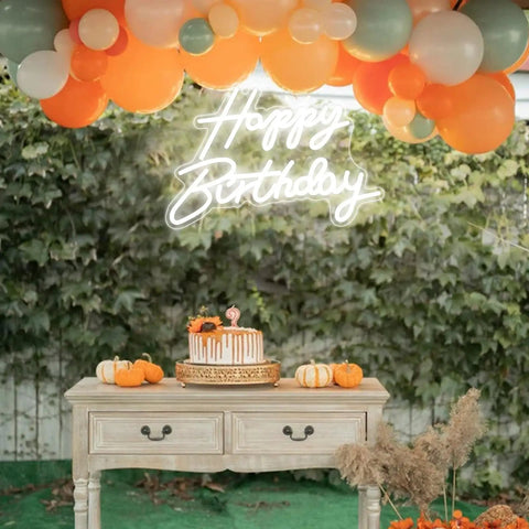 LED Neon Happy Birthday Sign Night Light For Party Backdrops And Bedroom Wall Decor above a decorated table at a party.
