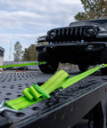Heavy Duty Axle Tie Down Kit Featuring Hella Bright Neon Green 2 Inch Webbing And Reliable Wire J Hook Ratchet Straps for vehicle securement on flatbed.