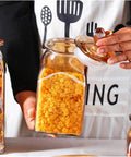 Top Shelf Durable Borosilicate Glass Jar Slick Amber Tint Secure Flip Lid Seal Keep Your Coffee Beans Spices And Dried Fruit Fresh In Style No Sweat Kitchen Pantry Organization Solution That Goes Hard with yellow cereal inside.