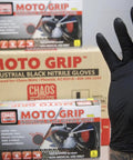 Box of Moto Grip industrial black nitrile gloves with a hand wearing one glove in front, size large, for repair and chemical work.