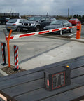 Pro Grade Vehicle Loop Detector for Automatic Doors and Parking Gates with sensitivity controls on a table near gate.