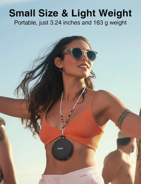 Woman wearing a compact portable speaker around neck, small size, lightweight, suitable for travel or outdoor use.