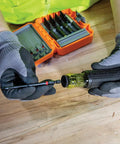 Person using 26-Piece Impact Driver Bit Set With Nut Driver And Screwdriver Bits In Durable Case on wooden table.