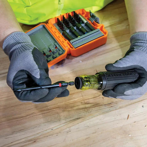 Person using 26-Piece Impact Driver Bit Set With Nut Driver And Screwdriver Bits In Durable Case on wooden table.