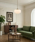 Vintage Brass Milk Glass Pendant Light 13.8in White Pleated Chandelier, E26 hanging over a green sofa in a stylish living room.