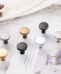 Assorted cabinet knobs on a marble surface, featuring different finishes and styles complementing the Ten Pack Oil Rubbed Bronze Knobs.