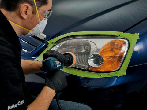 Person using Ultra Headlight Restoration Kit With Masking Tape Sanding Discs Finishing Discs Refining Disc Wax Protectant Clear Coat