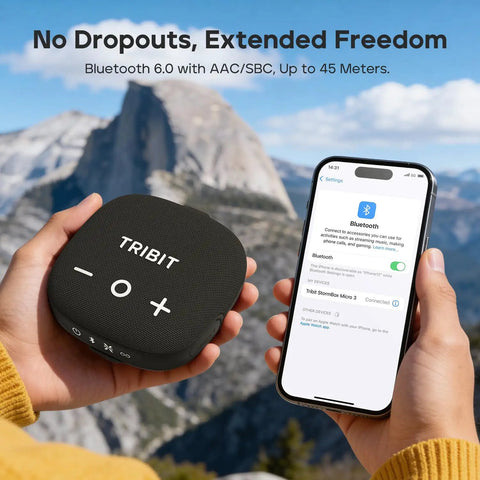 Person holding StormBox Micro 3 Portable Bluetooth Speaker With IP68 Waterproofing, compatible phone shows connection in mountain setting.