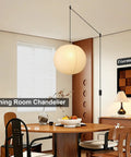 Twenty Inch Off White Japanese Rice Paper Lantern Plug In Pendant Light With Adjustable Cord Sets over a dining table in a cozy room setting.