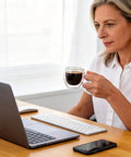 Woman holding Six Pack Double Wall Insulated Espresso Cups With Handles Clear Borosilicate Glass Shot Glasses at desk