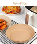 Go-To 6.5 Inch Round Air Fryer Paper Liners with chicken, fries, and pizza beside white air fryer