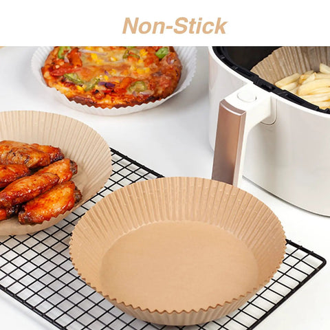 Go-To 6.5 Inch Round Air Fryer Paper Liners with chicken, fries, and pizza beside white air fryer