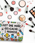 Just One More Geocache I Promise Makeup Bag among cosmetics and brushes, showing outdoor-themed design on canvas.