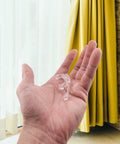 Premium Clear Double Slat Valance Clips To Tuck Away Mini Blind Brackets in hand, sturdy plastic, two inches wide.