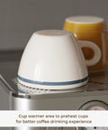 Compact Espresso Machine With 20 Bar Pressure And Digital Temp Display Built In Milk Frother for warming cups on top.