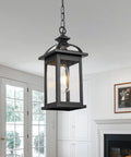 Weatherproof Outdoor Pendant Lantern in black with seeded glass, hanging in a living room setting, 13.6 inch tall, IP65 rated.