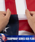 Hands holding US Flag 3x5 Outdoor Heavy Duty Nylon With Fade Resistant Embroidered Stars And Sewn Stripes Brass Grommets Built To Last
