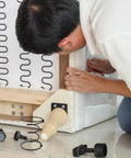Person repairing a couch with Heavy Duty Six Inch Sofa Spring Repair Kit, ensuring solid support for furniture restoration.