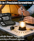 115 In 1 Precision Screwdriver Set For Phone Computer Watch Console Eyeglasses And Electronics Portable Gray Pro Repair Tool Kit displayed on table outdoors with open case and lantern.