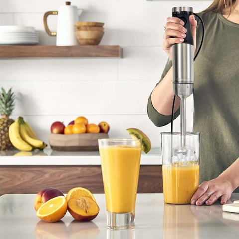 Badass Handheld Immersion Blender With Turbo Pulse Power And Four Rock Solid Stainless Blades, Includes Quick Snap Chopper Bowl And Wire Whisk To Crush Blending Jobs Without Breaking A Sweat in use making a smoothie.