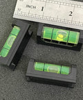 2Pack Magnetic Bubble Levels With Heavy Duty Iron Grip Solid Acrylic Spirit Level on a dark surface with ruler measuring size.