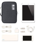 Waterproof Electronics Travel Organizer Bag With Double Layer Tangle Free Pockets beside tech gadgets like cables, tablet, and phone.
