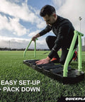 Man assembling 4-In-1 Soccer Rebounder Board For Backyard Training, Portable Dual Surface And Dual Angle Rebounds on grass field.