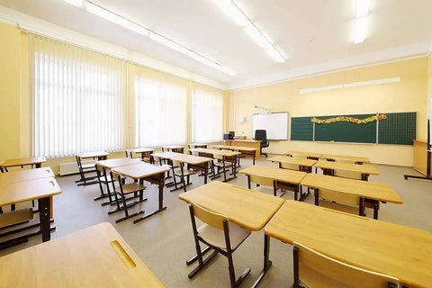 Empty classroom with 24 Pack 17W T8 Fluorescent Tube Light Bulbs 4100K Cool White 24 Inch G13 Base lighting, desks, and board.