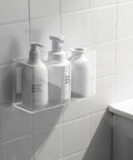 Bathroom wall with clear acrylic organizer holding three lotion bottles