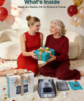 Two women exchanging a gift with 67 Inch Cordless Heating Pad For Back Pain Relief and packaging on the floor, festive setting.