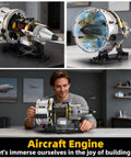 Jet Engine Kit With Motor And LED Light Turbofan Engine Building Set 564 Pieces model on desk with person building it.