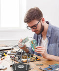 Man using Adjustable Soldering Support Tool With Universal Clamp And Helping Hands, Pro Grade Soldering Station Kit for PCB work