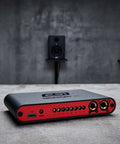 GIGAPORT Ex DJ Audio Interface with USB Type C power, featuring eight RCA outputs and dual headphone jacks, on a concrete surface.