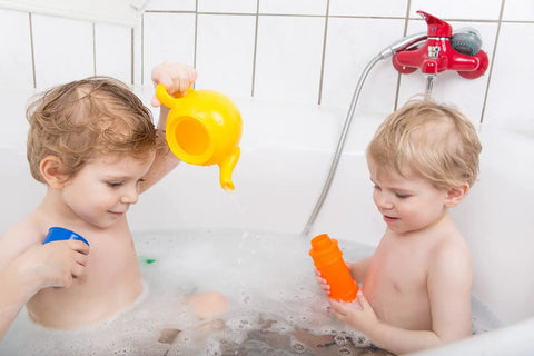 Two children playing with toys in a bathtub