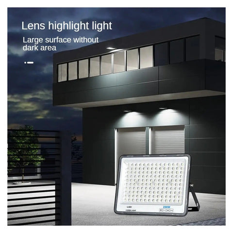 JUDYSSY Super Bright Led Floodlight 200W in use, illuminating an outdoor garage area at night, with a clear light and weatherproof design.