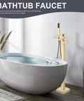 Gold Polished Floor Mounted Tub Filler Faucet With Handheld Sprayer next to modern freestanding bathtub